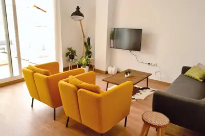 a living room with yellow chairs and a table at Hola Valencia - Holiday Apartments in Valencia