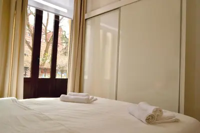 a bedroom with two towels on a bed with a window at Hola Valencia - Holiday Apartments in Valencia