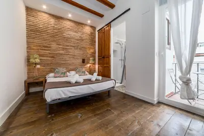 a bedroom with a bed and a brick wall at My Loft 4 You Ruzafa Style II in Valencia