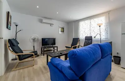 a living room with a blue couch and chairs at Malvarossa apartment near beach in Valencia