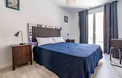 a bedroom with a bed with a blue blanket on it at Malvarossa apartment near beach in Valencia
