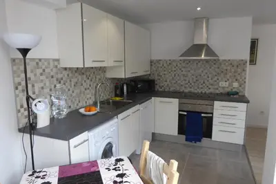 a kitchen with white cabinets and a sink and a table at Malvarossa apartment near beach in Valencia