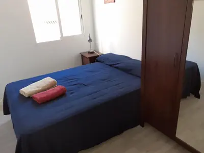 a bedroom with a blue bed with two red pillows at Malvarossa apartment near beach in Valencia