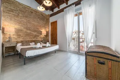 a bedroom with a bed and a brick wall at My Loft 4 You Ruzafa Style III in Valencia