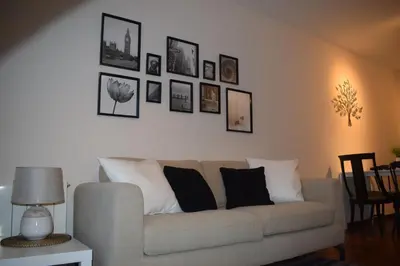 a living room with a couch and pictures on the wall at River Park Valencia in Valencia