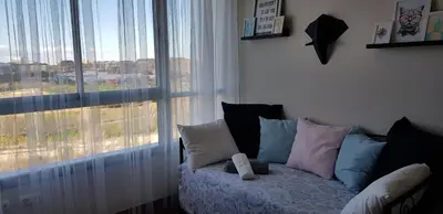 a living room with a couch and a large window at River Park Valencia in Valencia