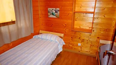a bedroom with a bed in a wooden wall at Bungalows Park Albufera in El Saler