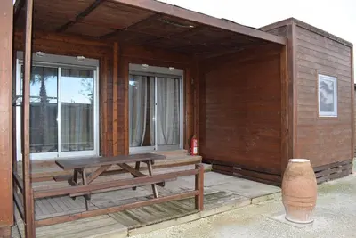 a wooden cabin with a picnic table and windows at Bungalows Park Albufera in El Saler