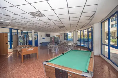 a pool table in a room with tables and chairs at Holiday Apartment Patacona Beach in Valencia