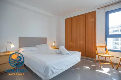 a bedroom with a bed and a desk and a chair at Holiday Apartment Patacona Beach in Valencia