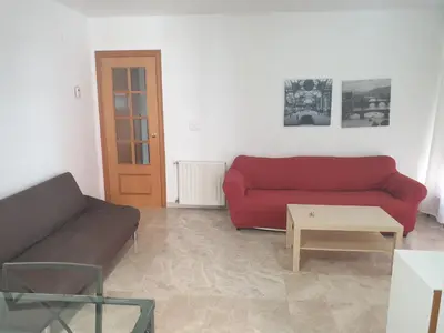 a living room with a red couch and a table at Oceanográfico Apartments in Valencia