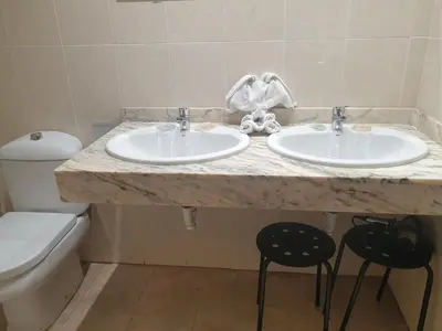 a bathroom with two sinks and a toilet at Oceanográfico Apartments in Valencia