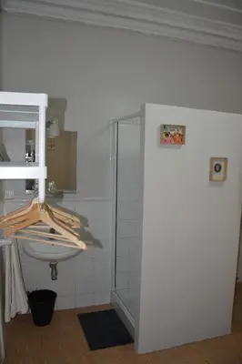 a white bathroom with a sink and a shower at Pensión Moratin in Valencia