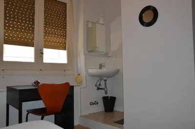 a small bathroom with a sink and a mirror at Pensión Moratin in Valencia