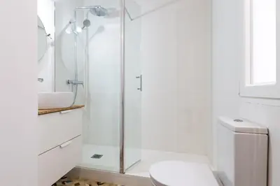 a white bathroom with a shower and a toilet at Casa Nolla in Valencia