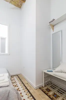 a white bedroom with a bed and a window at Casa Nolla in Valencia