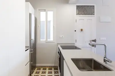 a white kitchen with a sink and a window at Casa Nolla in Valencia