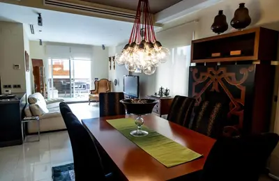 a dining room with a table and a chandelier at Travel Habitat Ático Ciutat Vella. in Valencia