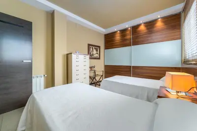 a bedroom with two white beds and a window at Travel Habitat Ático Ciutat Vella. in Valencia