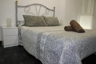 a bedroom with a bed with a metal headboard and pillows at María montessori, pedagoga in Valencia