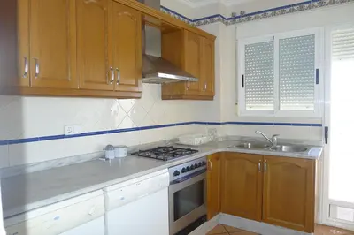 a kitchen with wooden cabinets and a stove top oven at Casa Esperanza in Alborache