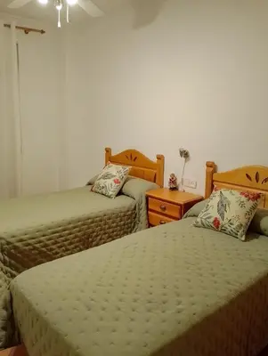 a bedroom with two beds and a dresser and a bedskirts at Casa Esperanza in Alborache