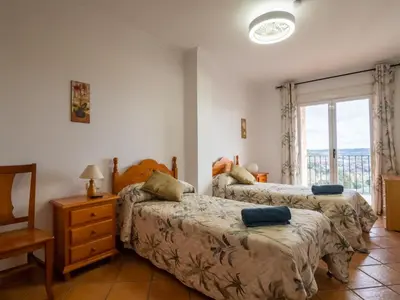 a bedroom with two beds and a dresser and a window at Casa Esperanza in Alborache