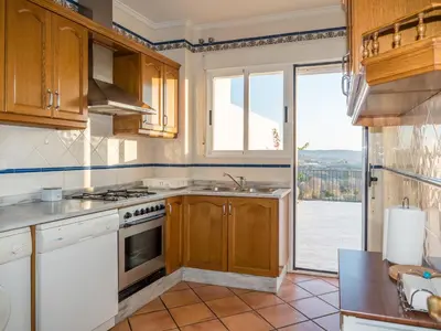 a kitchen with a stove and a sink and a window at Casa Esperanza in Alborache