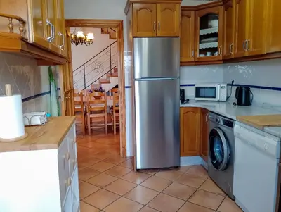 a kitchen with a stainless steel refrigerator and a table at Casa Esperanza in Alborache