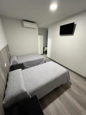 a room with two beds and a flat screen tv at Hospederia del Pilar in Valencia