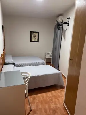 a room with two beds and a table and chairs at Hospederia del Pilar in Valencia