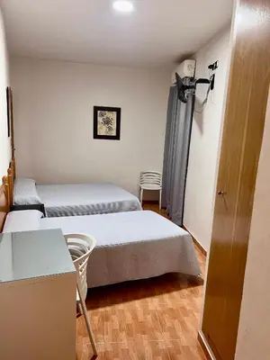 a room with two beds and a table and chairs at Hospederia del Pilar in Valencia