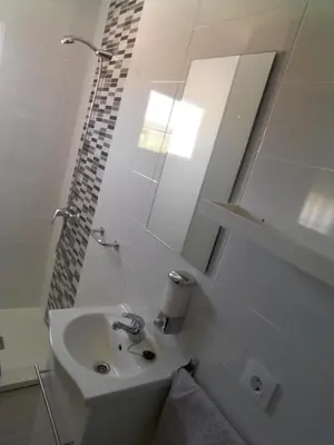 a white bathroom with a sink and a mirror at Pensíon Lucia in Casinos