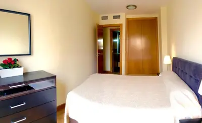 a bedroom with a bed and a dresser and a mirror at Sun Apartament Valencia @ City Arts & Sciences + Parking in Valencia