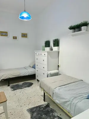a bedroom with two beds and a dresser and a blue light at Big spacious penthouse next to the sea in Valencia
