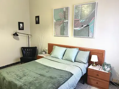 a bedroom with a bed and a chair in it at Big spacious penthouse next to the sea in Valencia