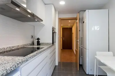 a kitchen and living room with a table and chairs at ApartUP Mestalla Home in Valencia