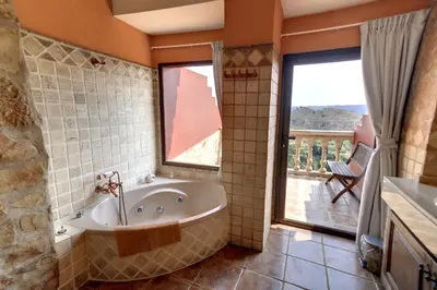 a bathroom with a tub and a large window at Casa Rural Mirador del Salto in Chella