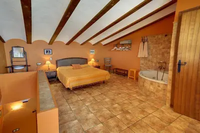 a bedroom with a bed and a bath tub at Casa Rural Mirador del Salto in Chella