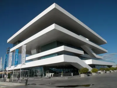 a building with people walking on a walkway next to the water at Puerto Bello in Valencia
