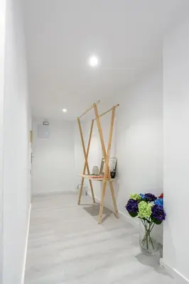 a white room with a table and flowers in a vase at Carmen Apartment in Valencia