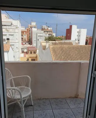 a balcony with two chairs and a view of a city at Apartment 400 meters from the beach in Valencia
