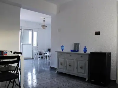 a living room with a table and blue vases on a cabinet at Apartment 400 meters from the beach in Valencia