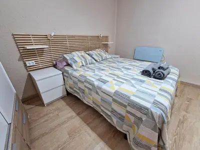 a bedroom with a large bed with a wooden headboard at Vive Valencia con playa y metro cerca in Valencia