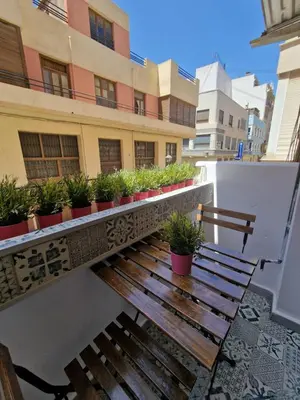a wooden bench on a balcony with potted plants at Vive Valencia con playa y metro cerca in Valencia