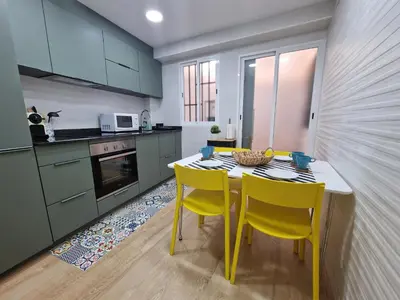 a kitchen with a table and two yellow chairs at Vive Valencia con playa y metro cerca in Valencia