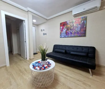 a living room with a black couch and a table at Vive Valencia con playa y metro cerca in Valencia