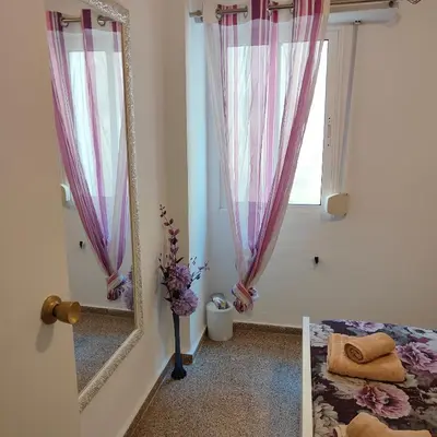 a mirror in a room with a bed and a window at Relaxed Space in the beach in Puerto de Sagunto