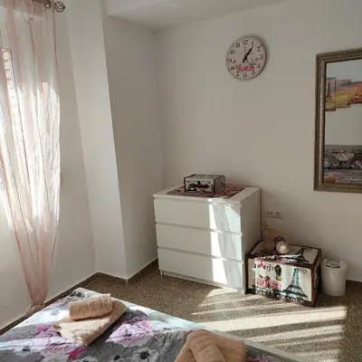 a bedroom with a dresser and a clock on the wall at Relaxed Space in the beach in Puerto de Sagunto