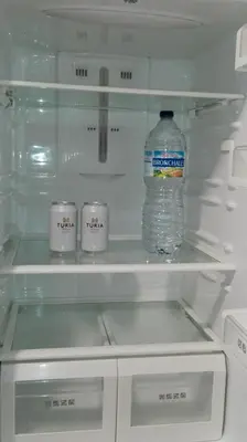 a bottle of water in an empty refrigerator at MÍ casa YOUR HOME in Valencia